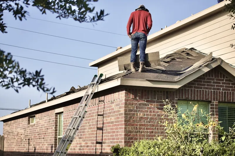 Professional roofer working on a residential roof in Brattle